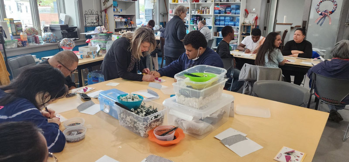Individuals working on a project at a table in an art studio setting