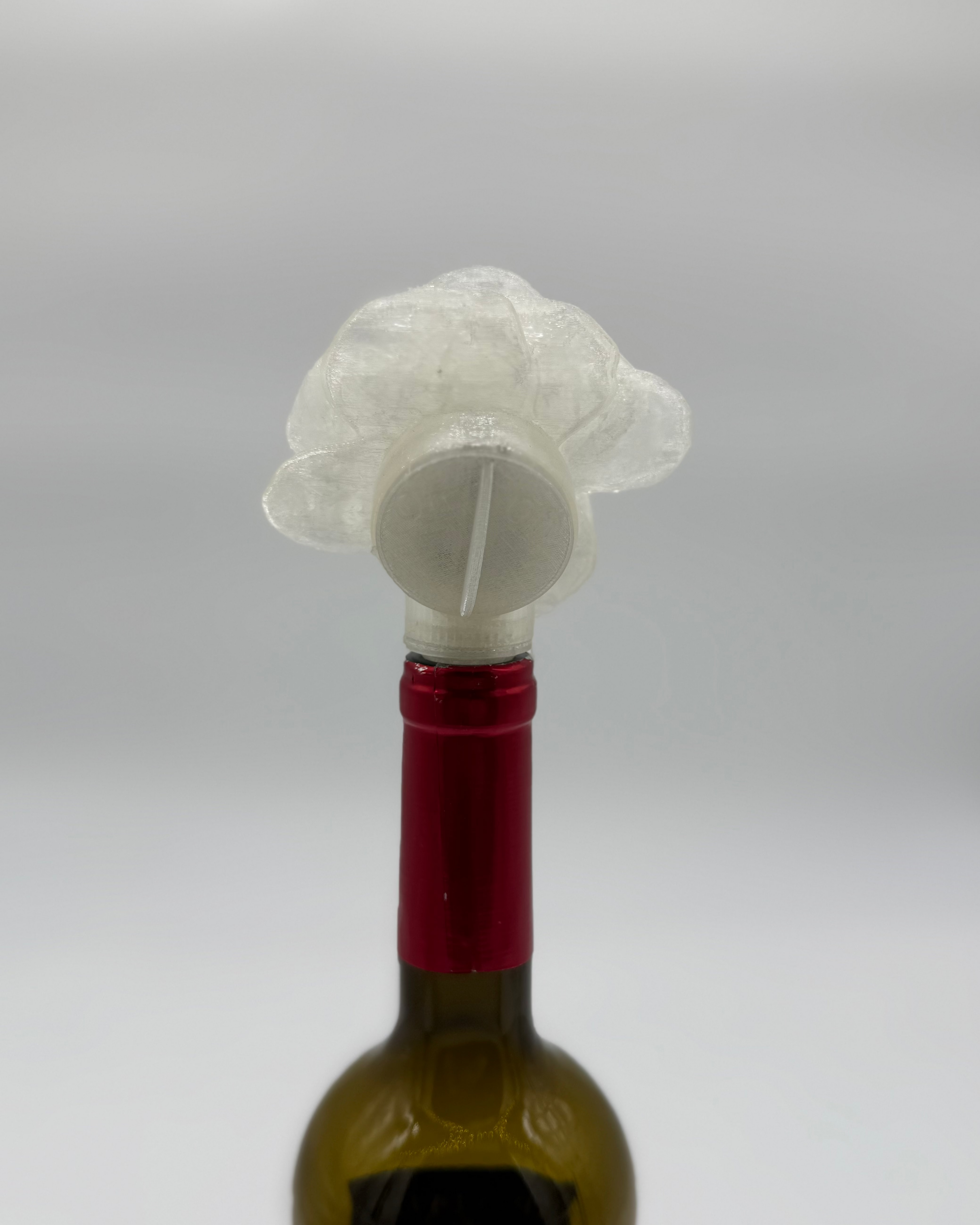 Wine bottle with a decorative stopper shaped like a rose on a white background
