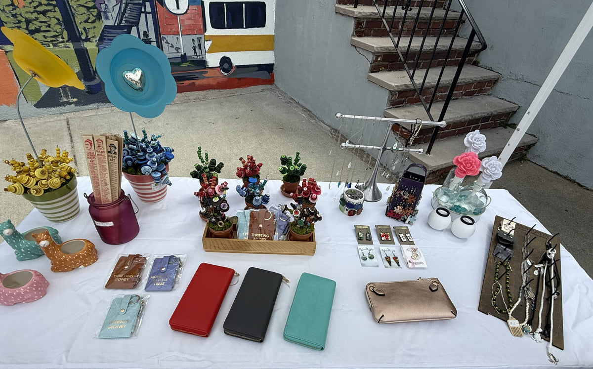 Table with various small decorative items and accessories outdoors.