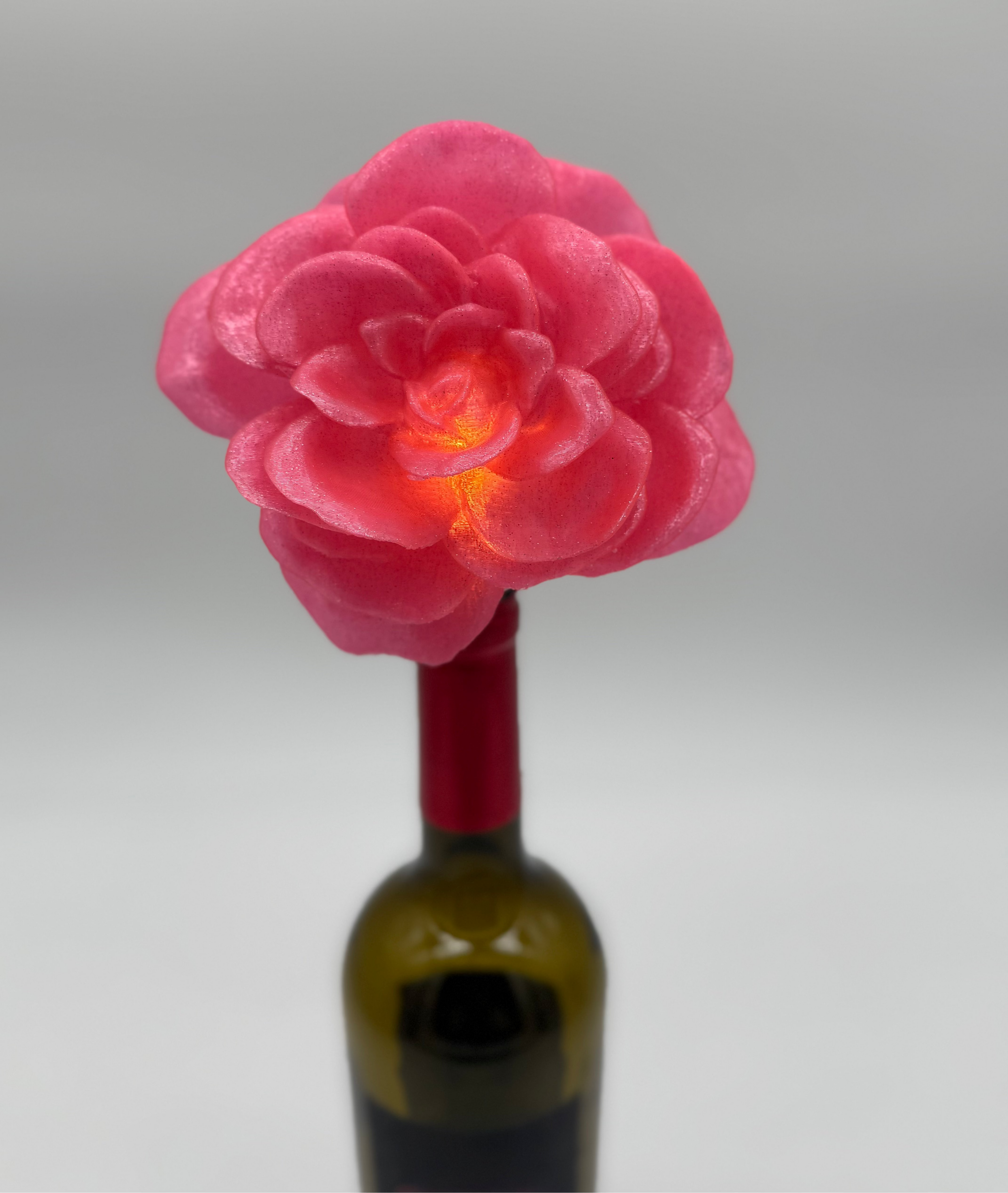Large pink sparkly flower bottle stopper in a wine bottle.