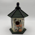 Decorative birdhouse with a black roof on a white background