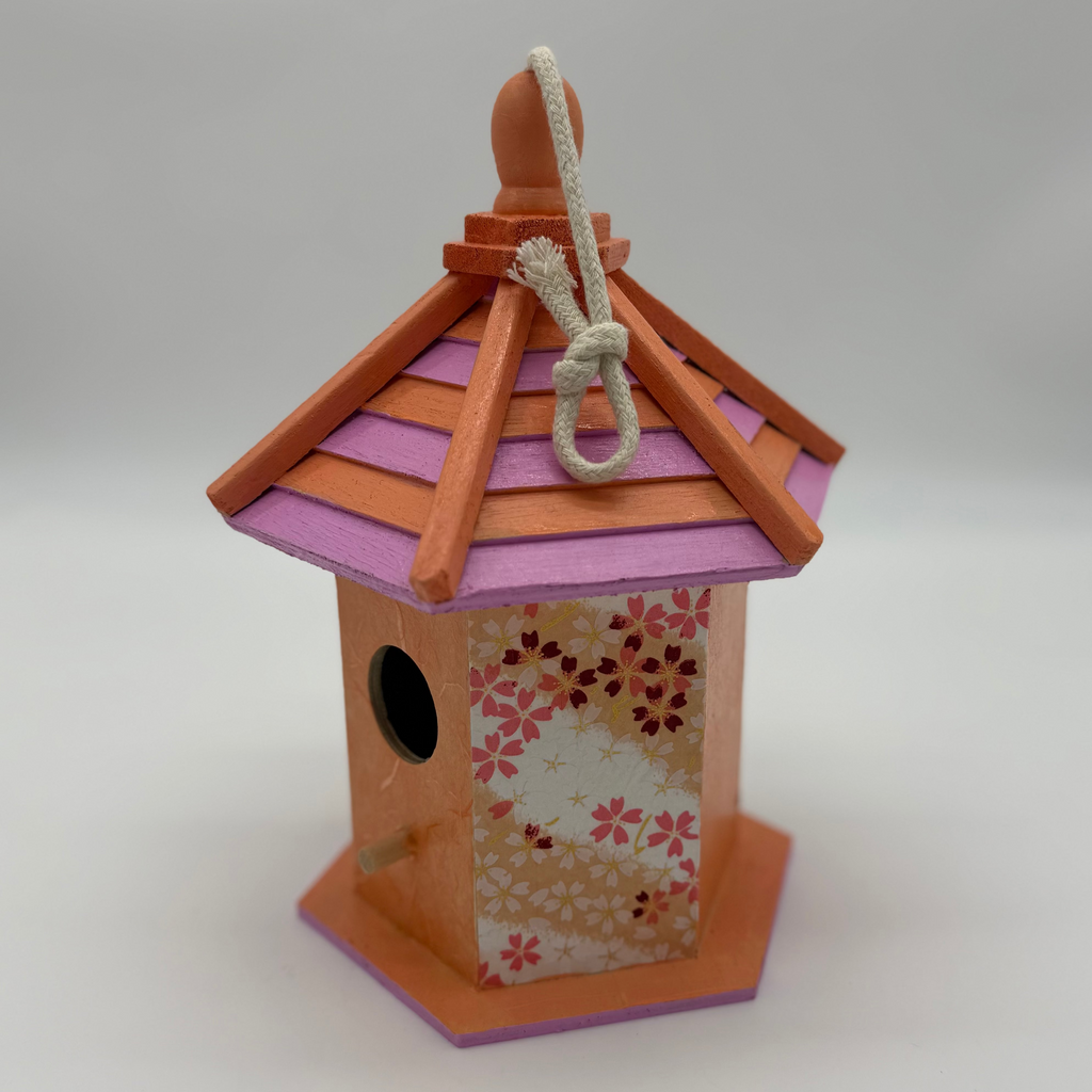 Decorative birdhouse with floral pattern on a white background