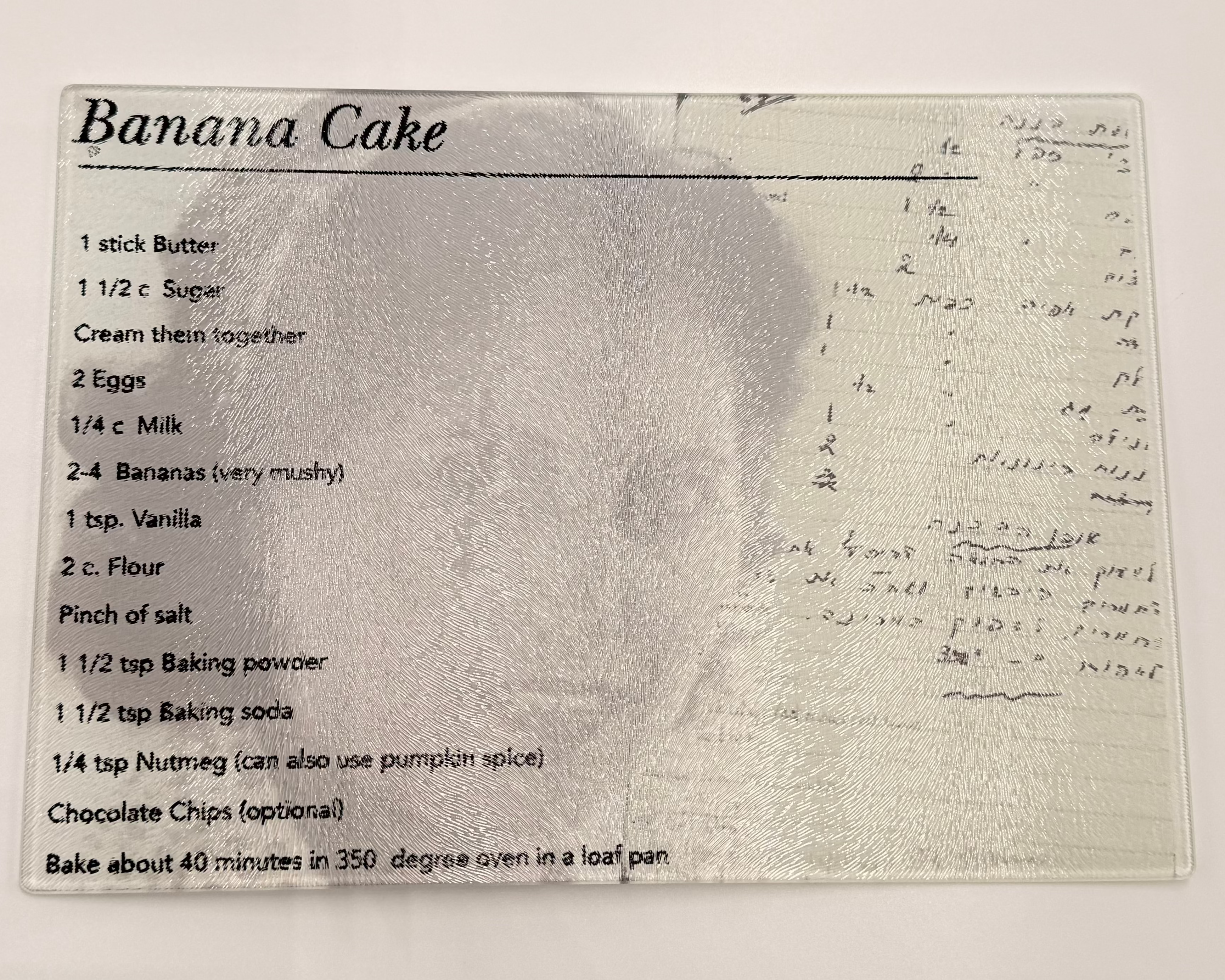 Banana cake recipe card on a textured glass cutting board