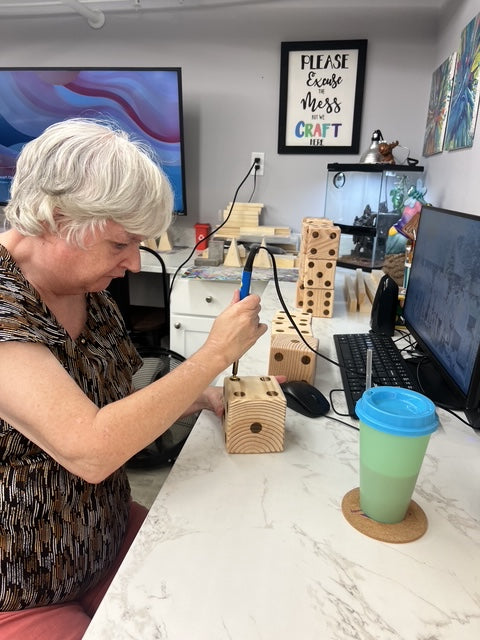 Young woman smiling, adding dots to large dice