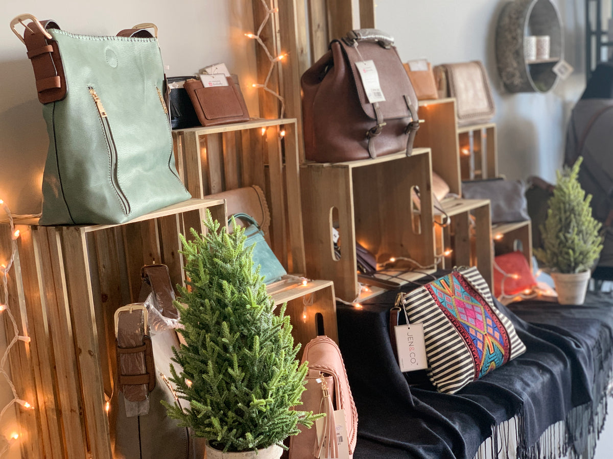 Handbags and decorative items displayed on wooden crates with a cozy indoor setting.