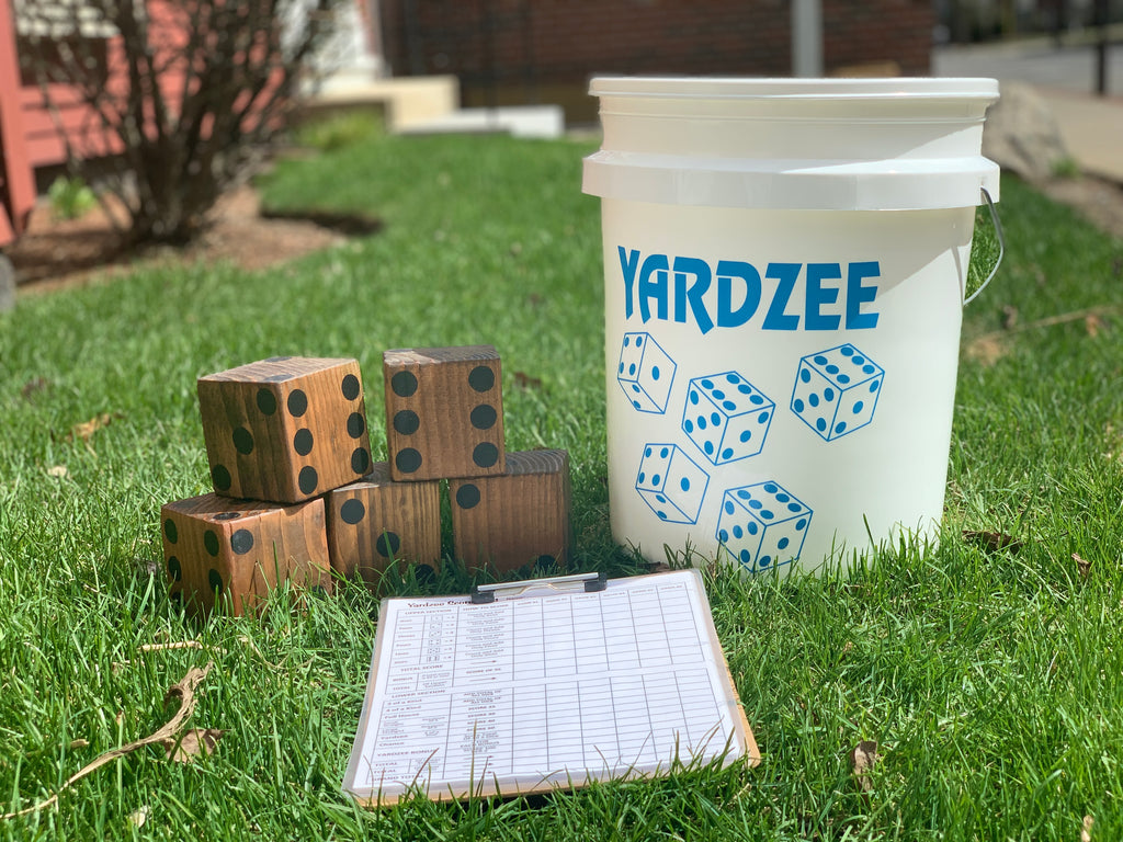 Yardzee game set with dice and score sheet on grass