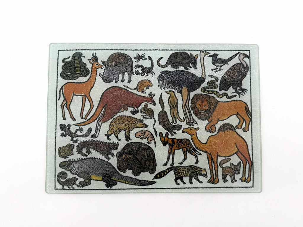 Collection of various animals in different poses on a white background on a glass cutting board