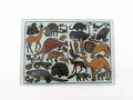 Collection of various animals in different poses on a white background on a glass cutting board