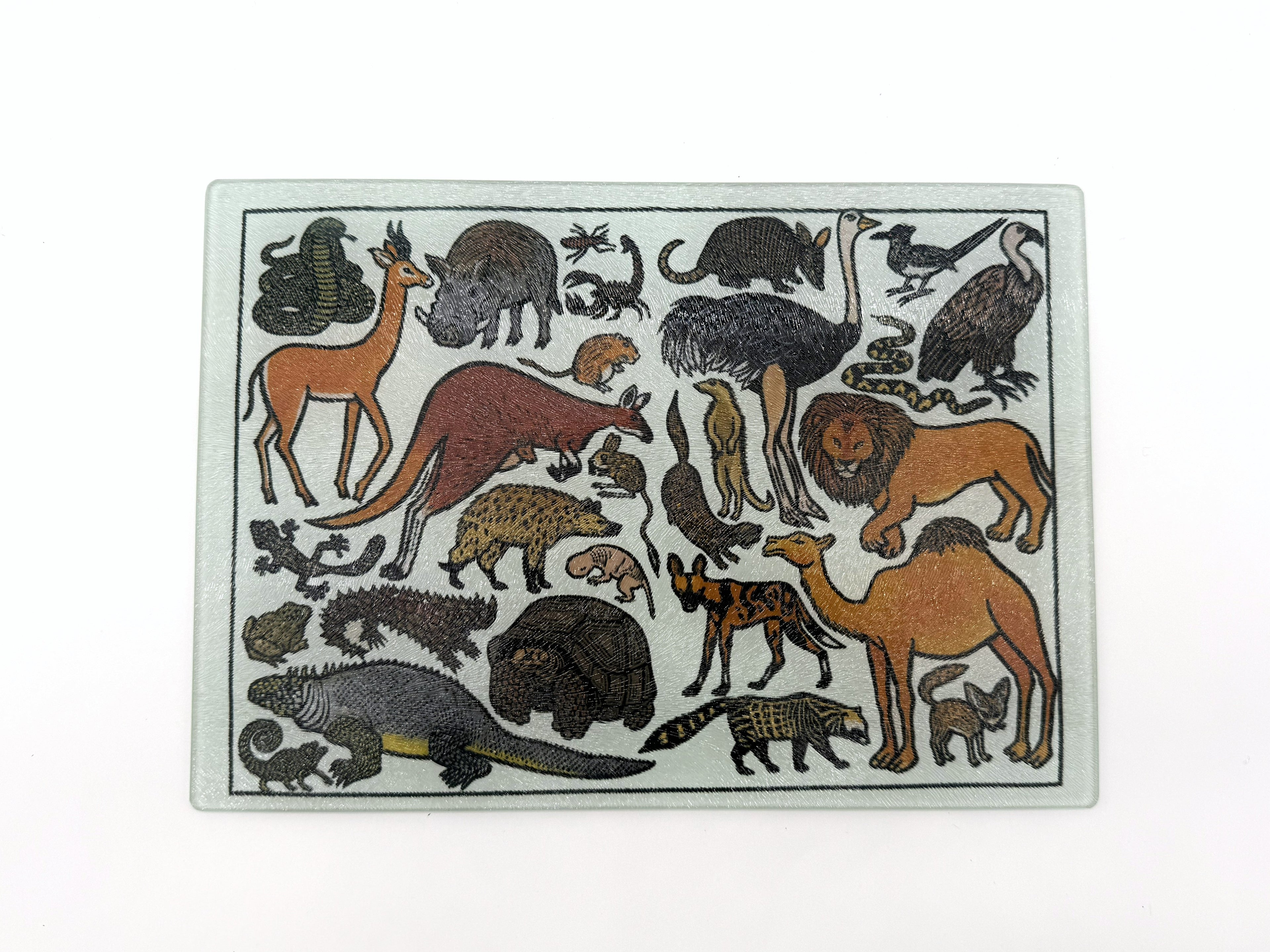 Collection of various animals in different poses on a white background on a glass cutting board