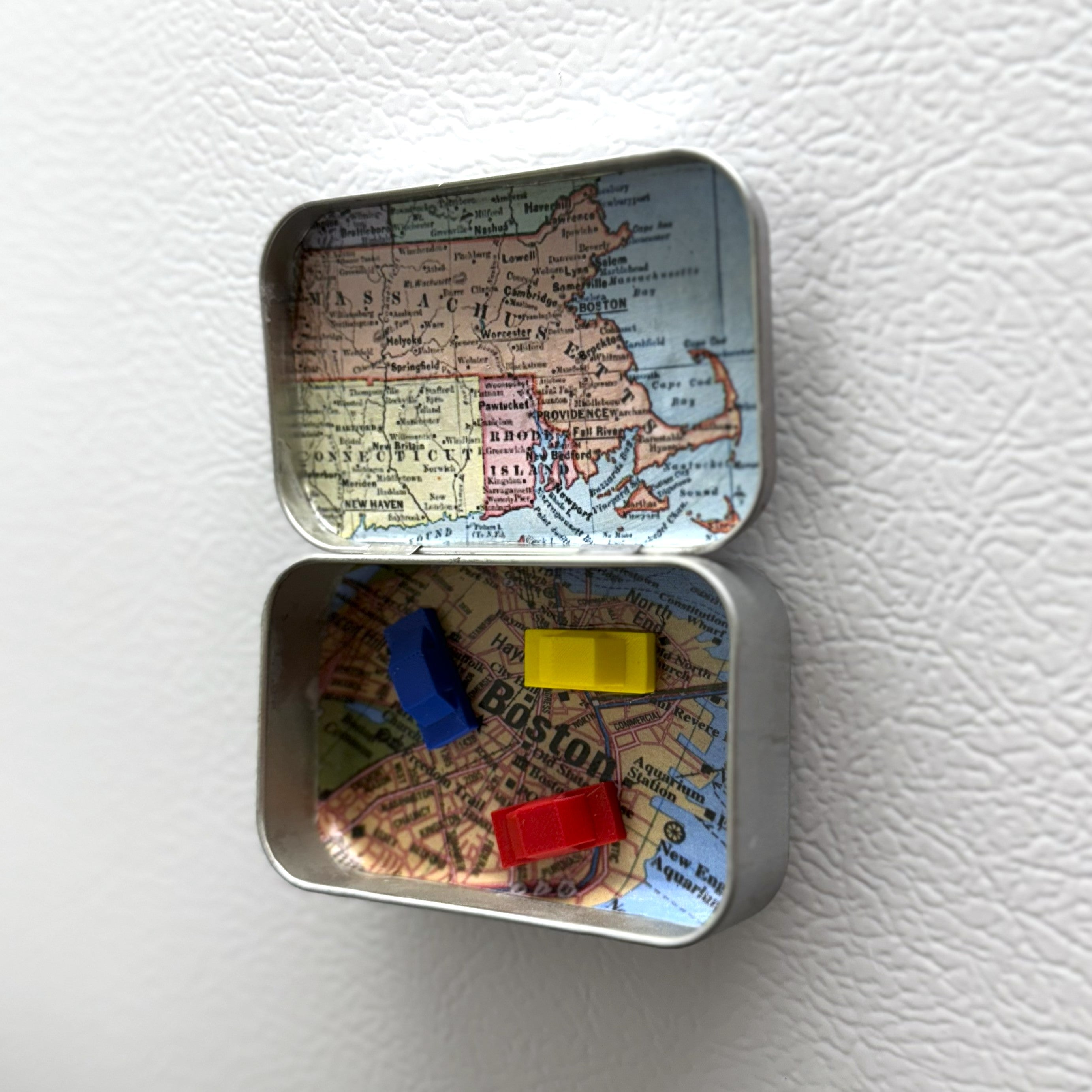Small tin box with a map design on a white surface