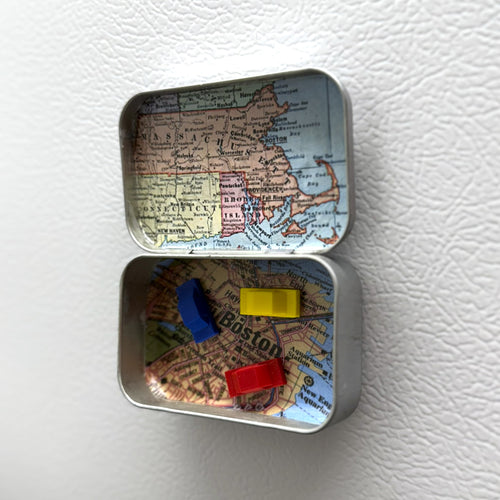 Small tin box with a map design on a white surface
