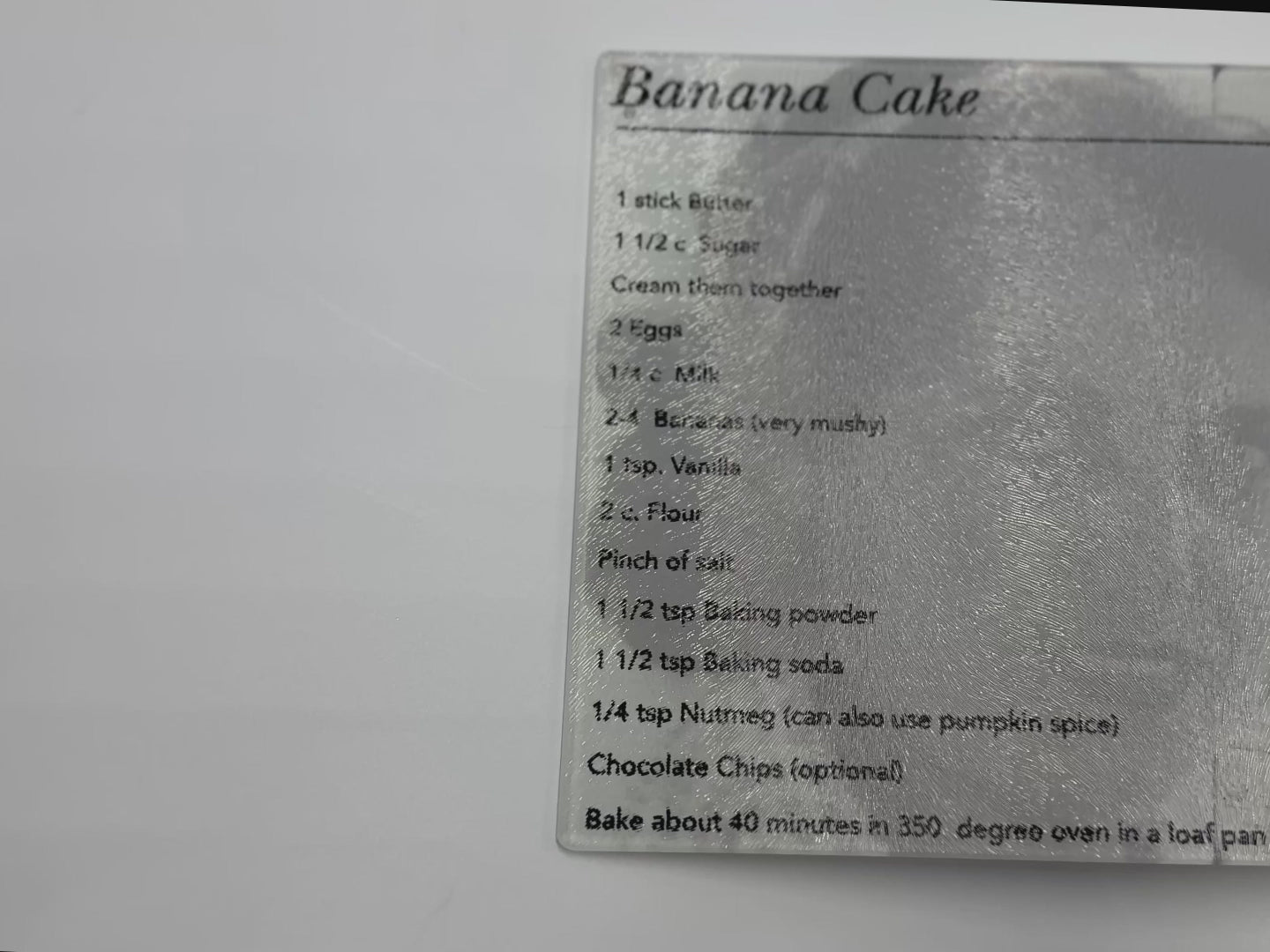video showing textured glass cutting board with a banana cake recipe on it
