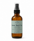 Brown spray bottle with green label that reads" instant beach day"