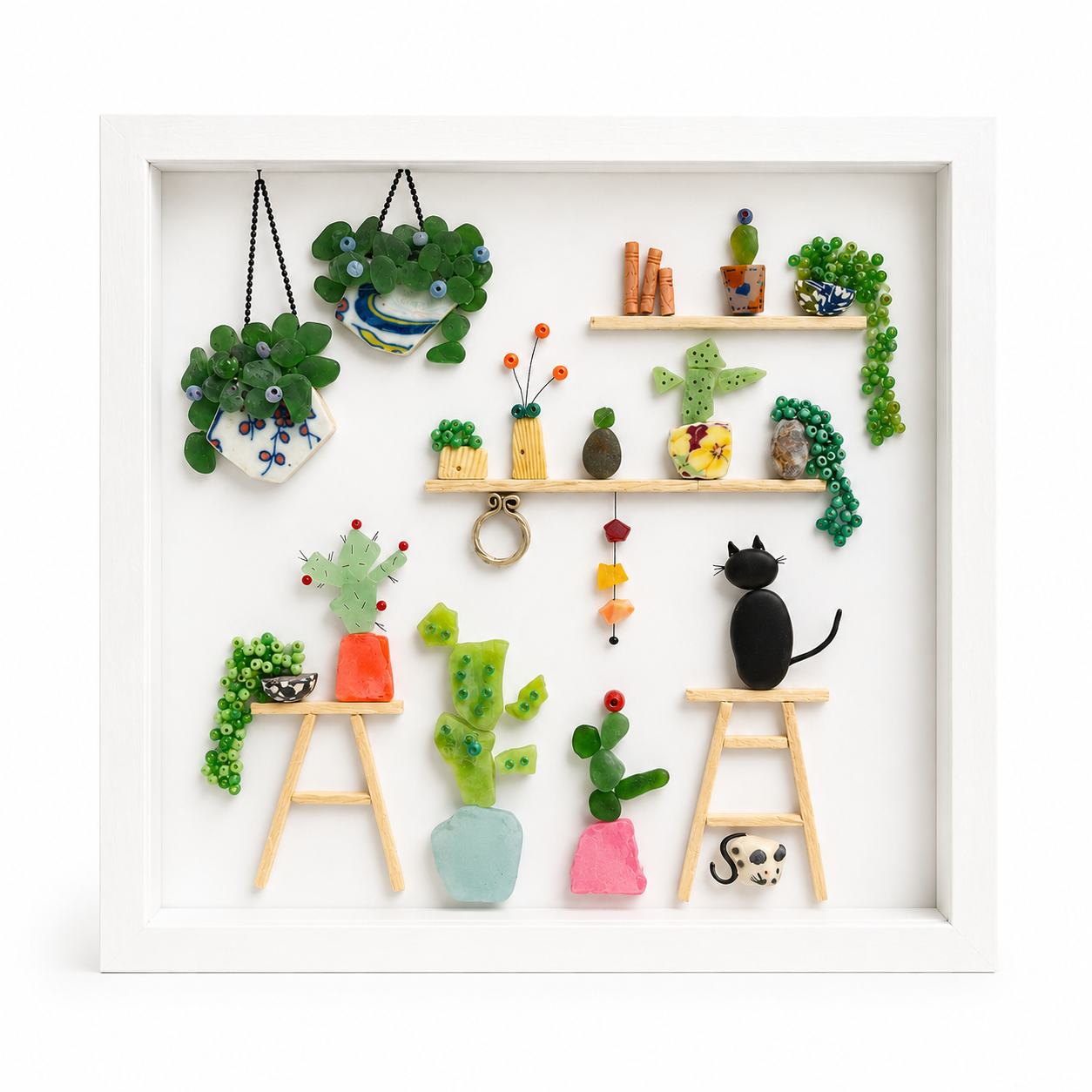 Collection of small items made of seaglass including plants and a cat figure on a white background